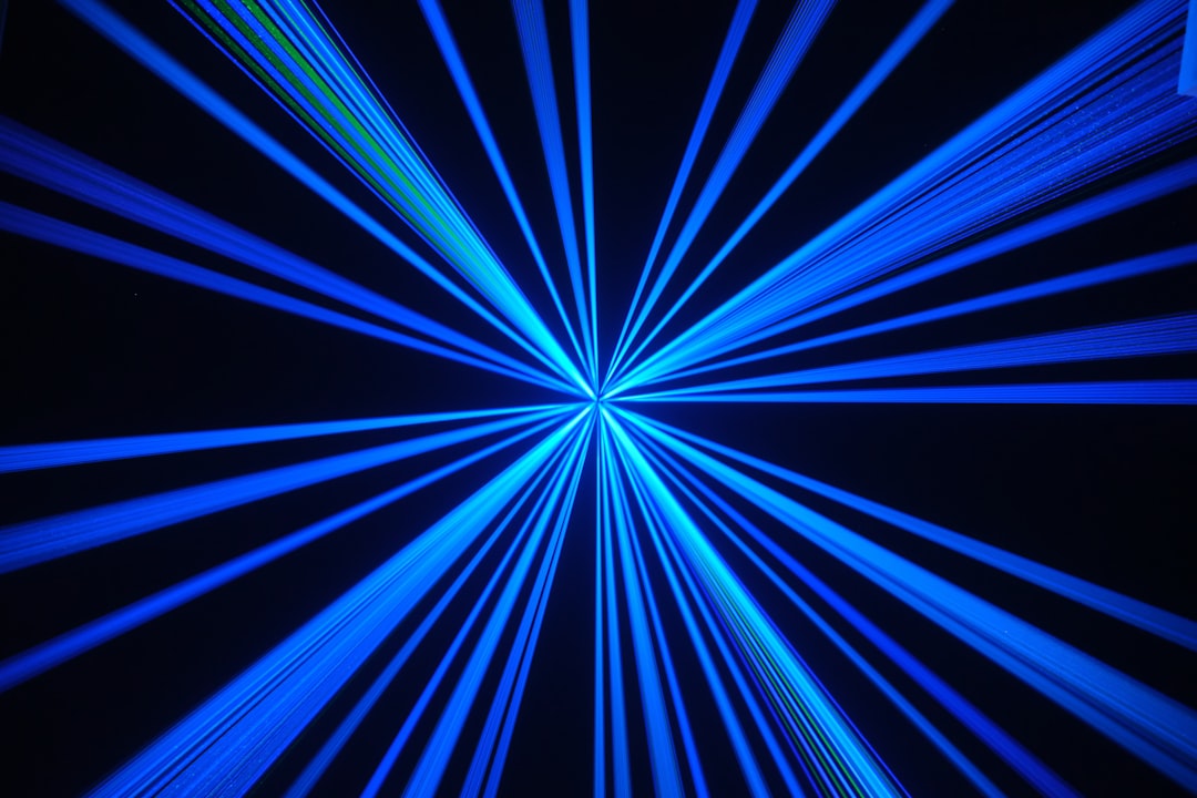 Blue laser rays radiating outward, symbolizing the laser-trapped atoms inside a neutral-atom quantum computer