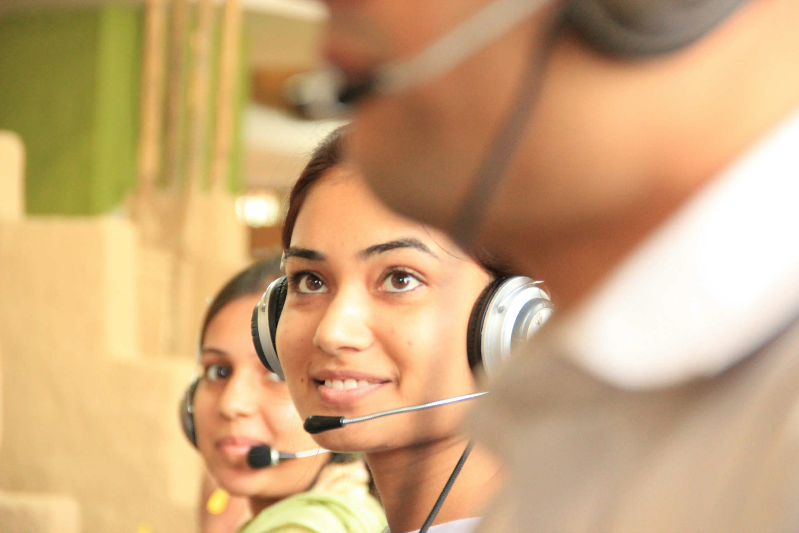 Two dispatchers wearing headsets work at an AI 911 dispatch and emergency call center