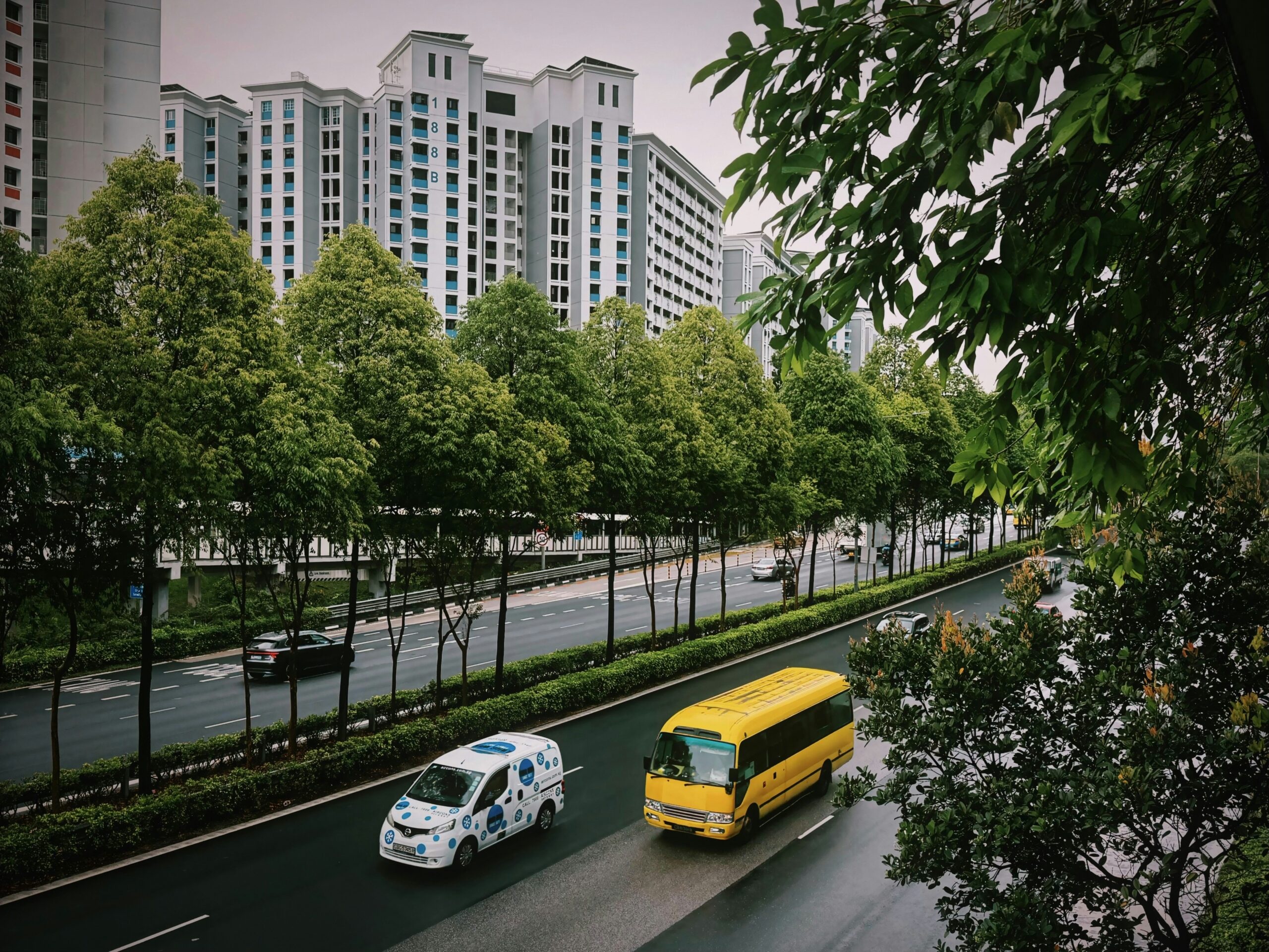 Small electric shuttle van and bus on a city street, representing autonomous microtransit service