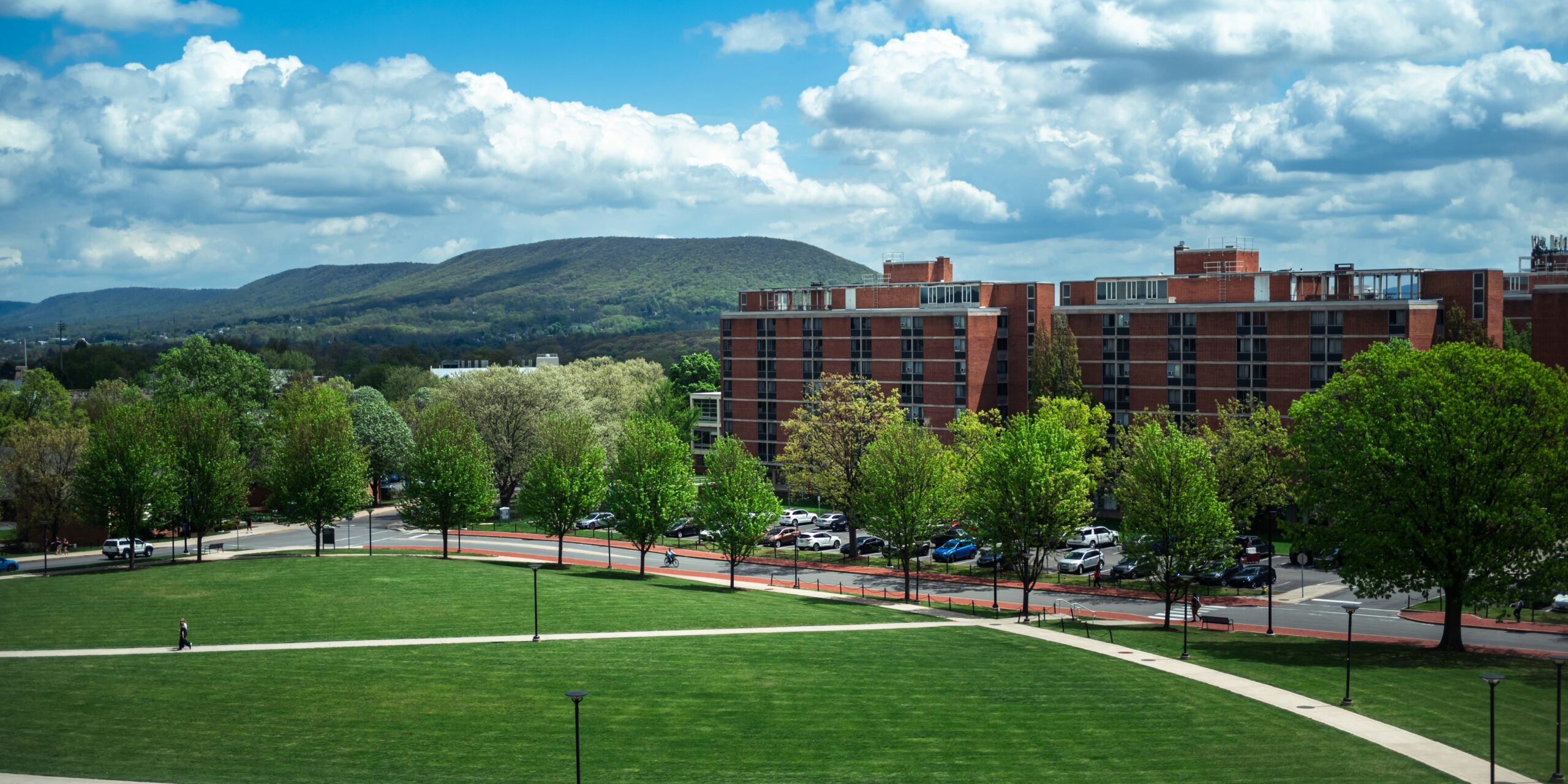 College campus buildings and green lawn, symbolizing a campus geothermal heating upgrade
