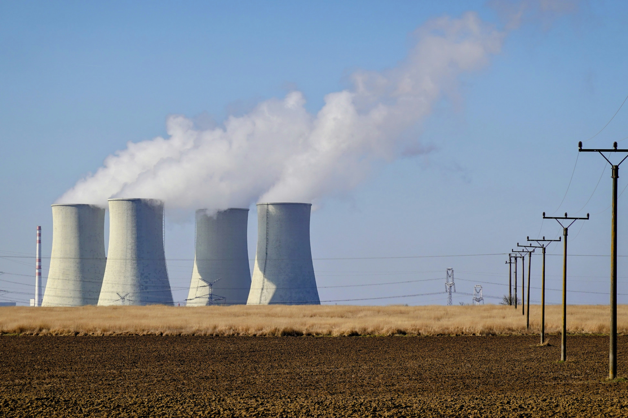 Nuclear power plant cooling towers releasing steam, symbolizing the TRISO-X fuel facility supplying advanced reactors