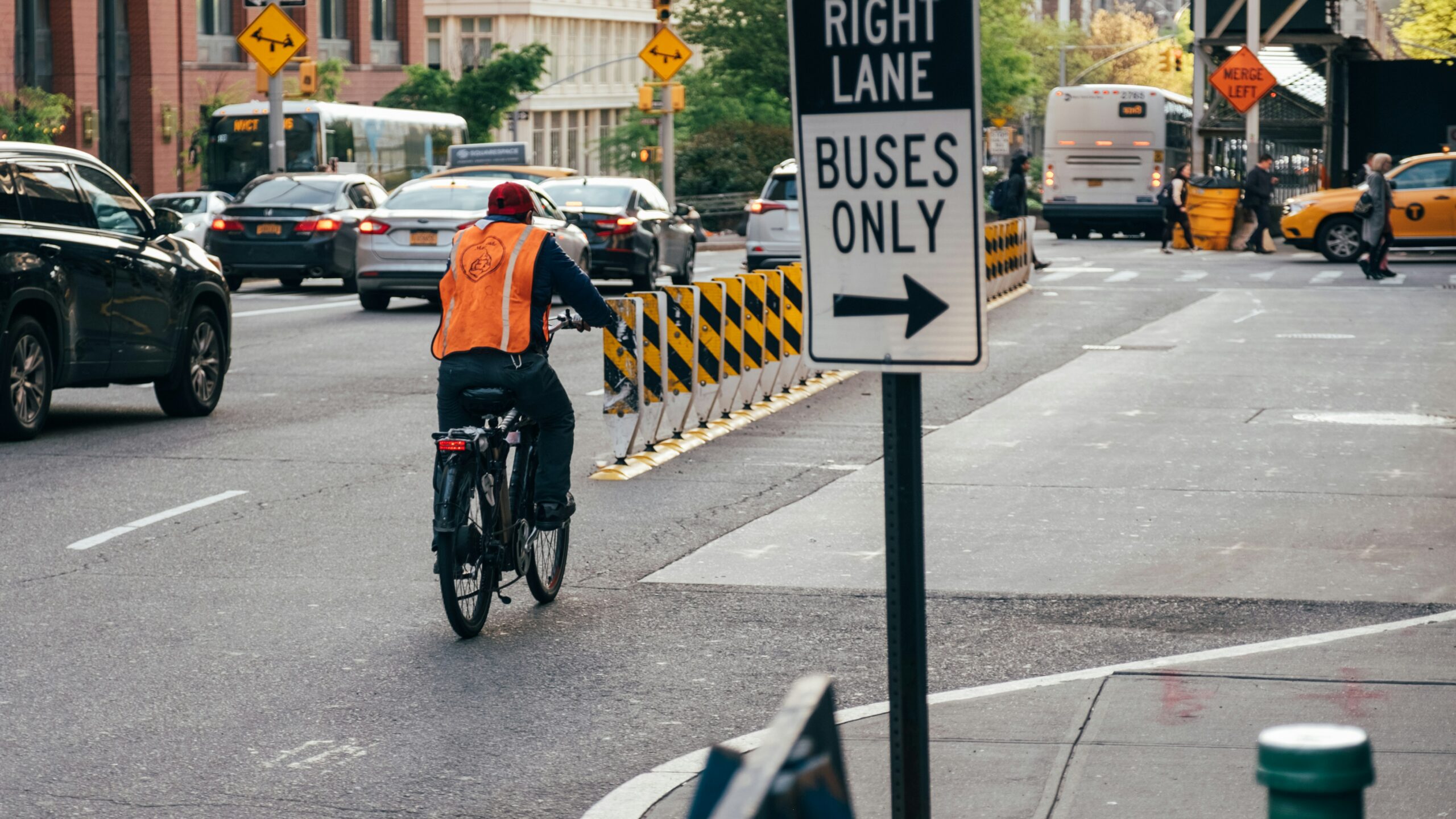 Cyclist riding past parked cars, illustrating why BMW active safety technology prevents dooring crashes