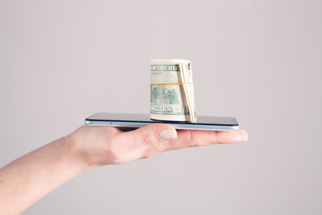 Person holding a smartphone, representing everyday Ethena Pay stablecoin savings and mobile money access