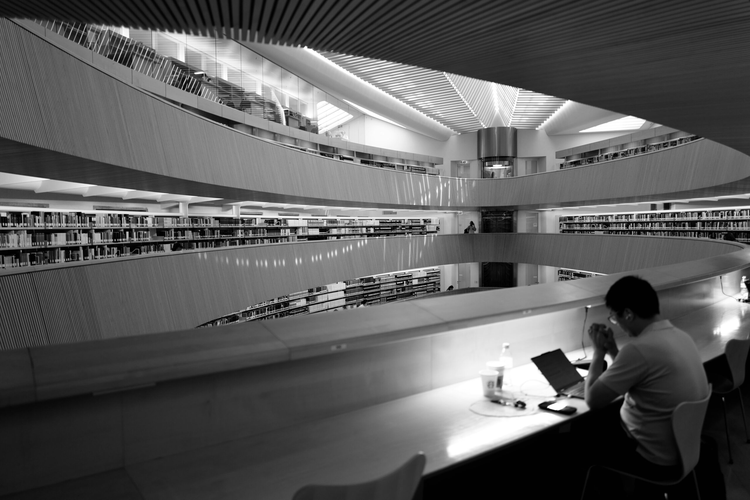 Person using a laptop in a library, reflecting Oklahoma library broadband portals for internet access