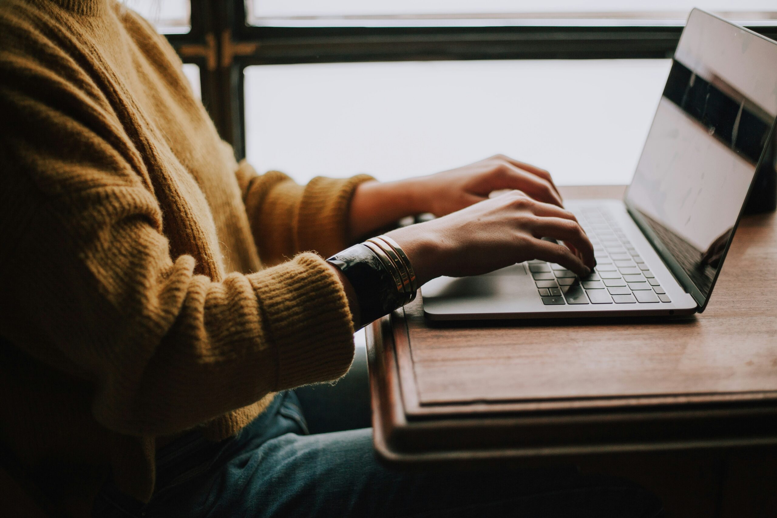 Hands typing on a laptop keyboard filing taxes online through the free Maryland Tax Connect portal