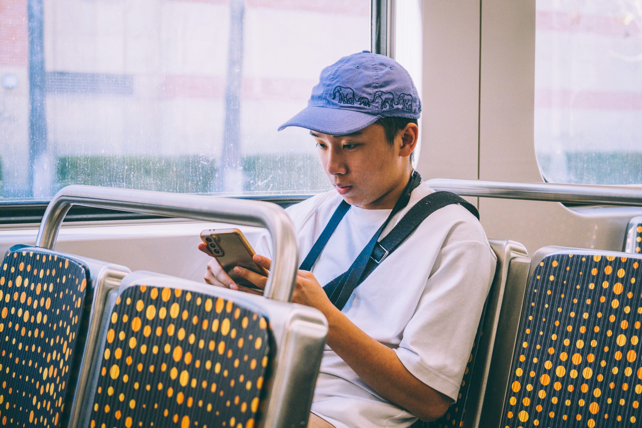 Commuter checks the NJ Transit AI chatbot Navvie on a smartphone while riding the bus