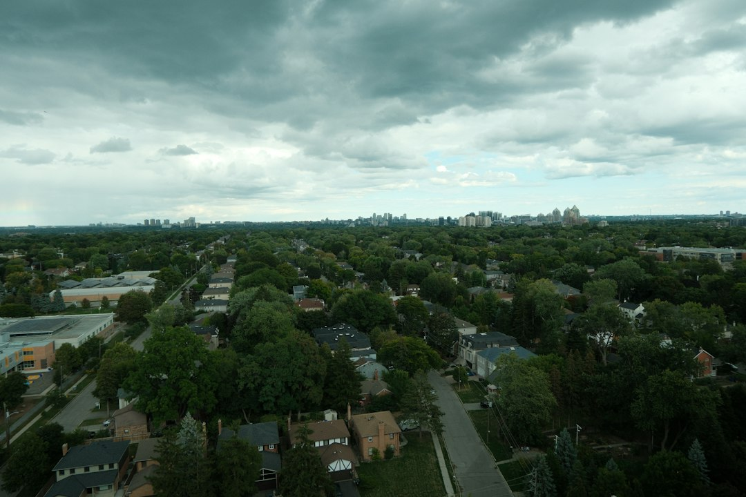 A residential neighborhood under storm clouds, the kind of outage a battery storage program is built to prevent
