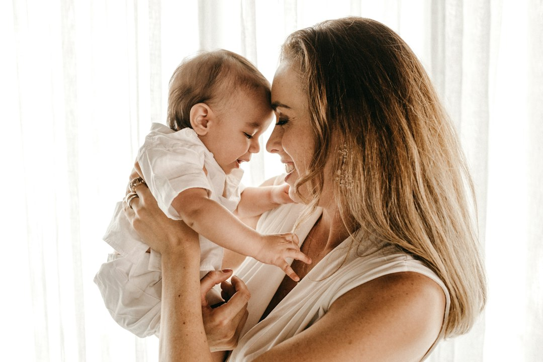 Smiling mother carrying her baby, representing families the New Jersey Doula Assistant helps connect with Medicaid doula support