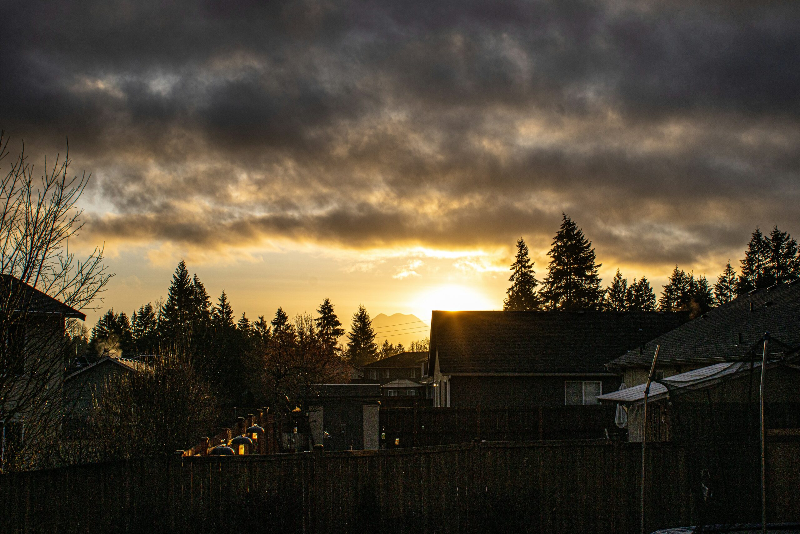 Dark storm clouds gathering over a neighborhood before a flash flood warning system alert