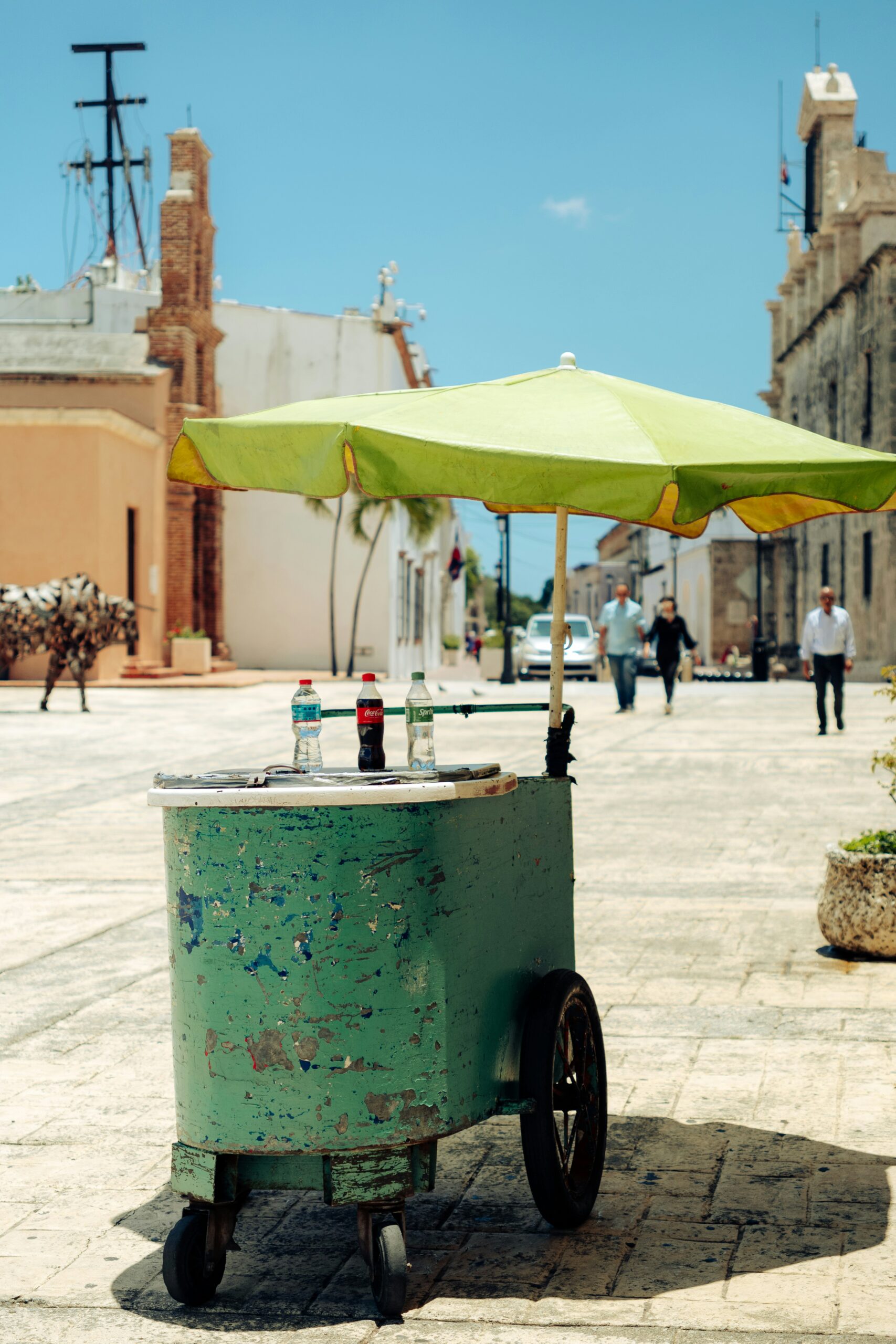 A green street food cart on a sunny sidewalk, symbolizing the shift from noisy generators to a food cart battery swap