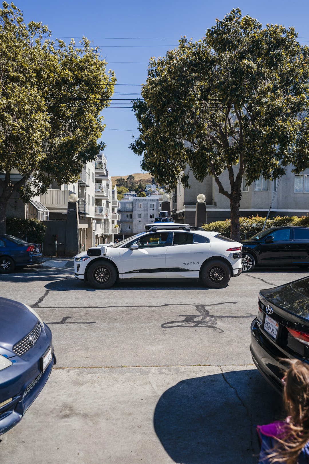 White self-driving car on a city street, symbolizing the new Texas self-driving car law
