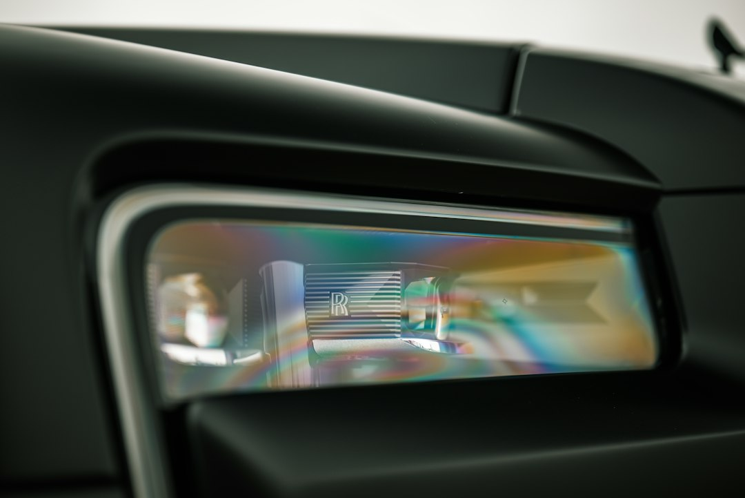 Close-up of a car headlight reflecting colored light, evoking the sensor technology behind Waymo's Tampa robotaxi launch
