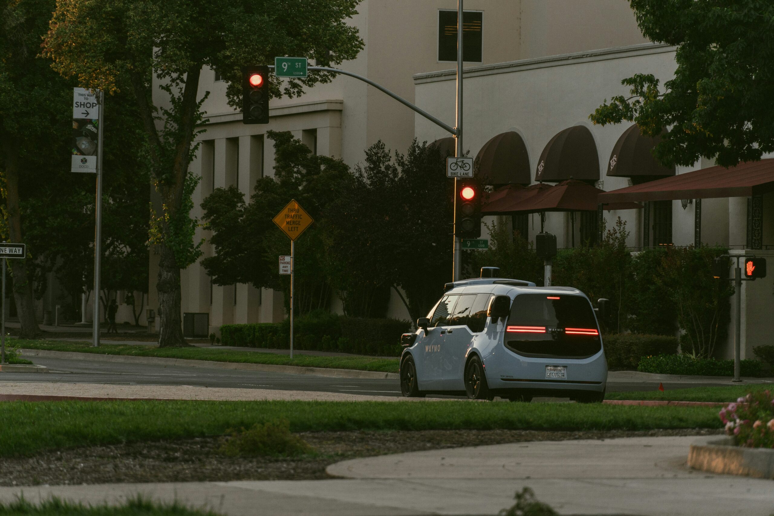 Light blue autonomous vehicle navigating a city intersection, representing the Zoox robotaxi Houston expansion