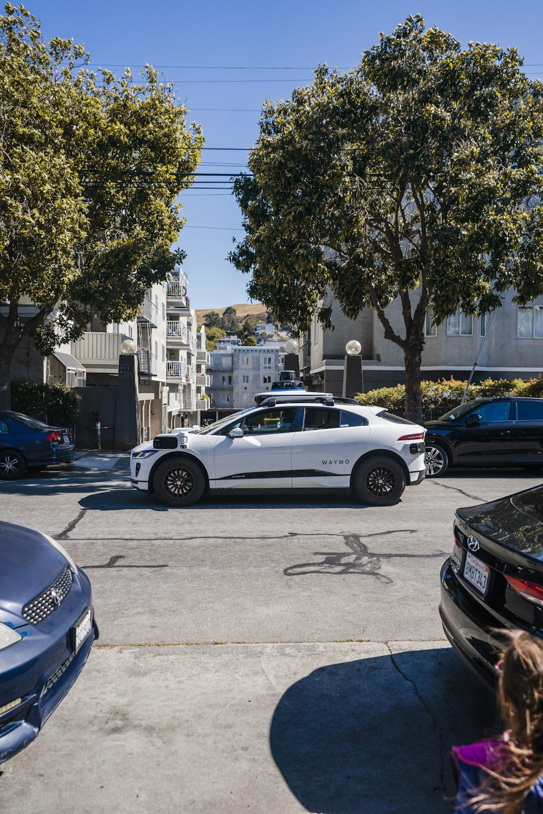 White self-driving car stopped on a city street, illustrating the California robotaxi safety law for emergency response