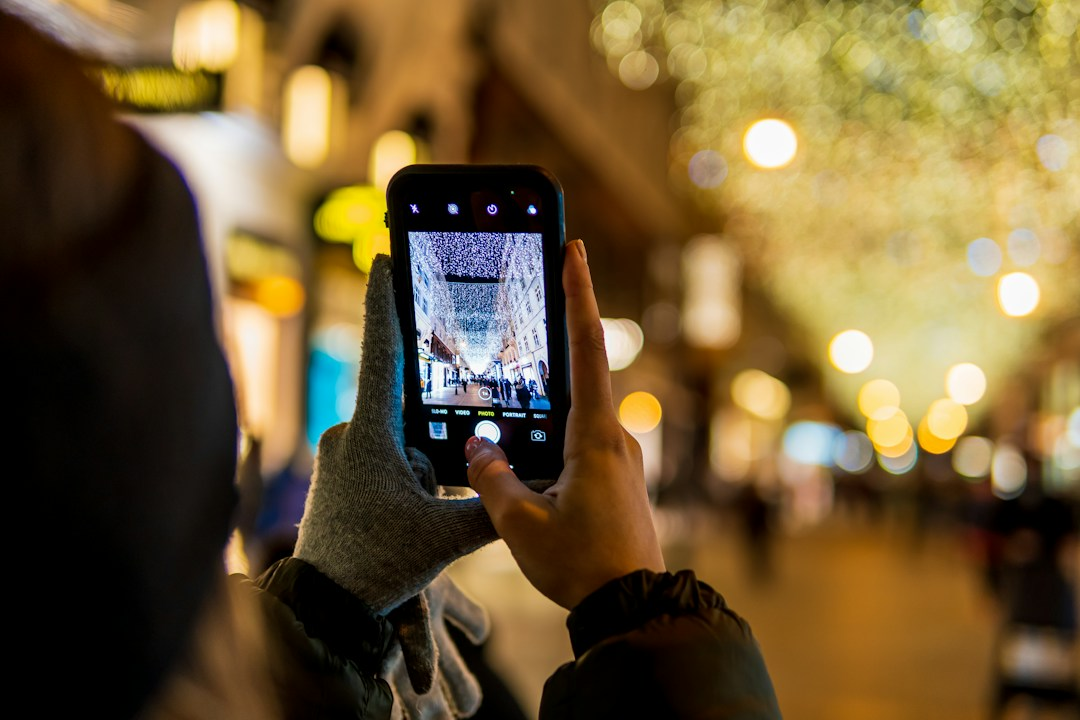 Person using a smartphone app on a city sidewalk, similar to Poughkeepsie's PK Connect app for reporting problems
