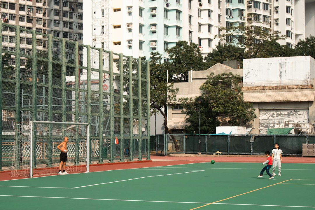 Kids and an adult playing on a community sports court, now bookable through Lee County's online registration system