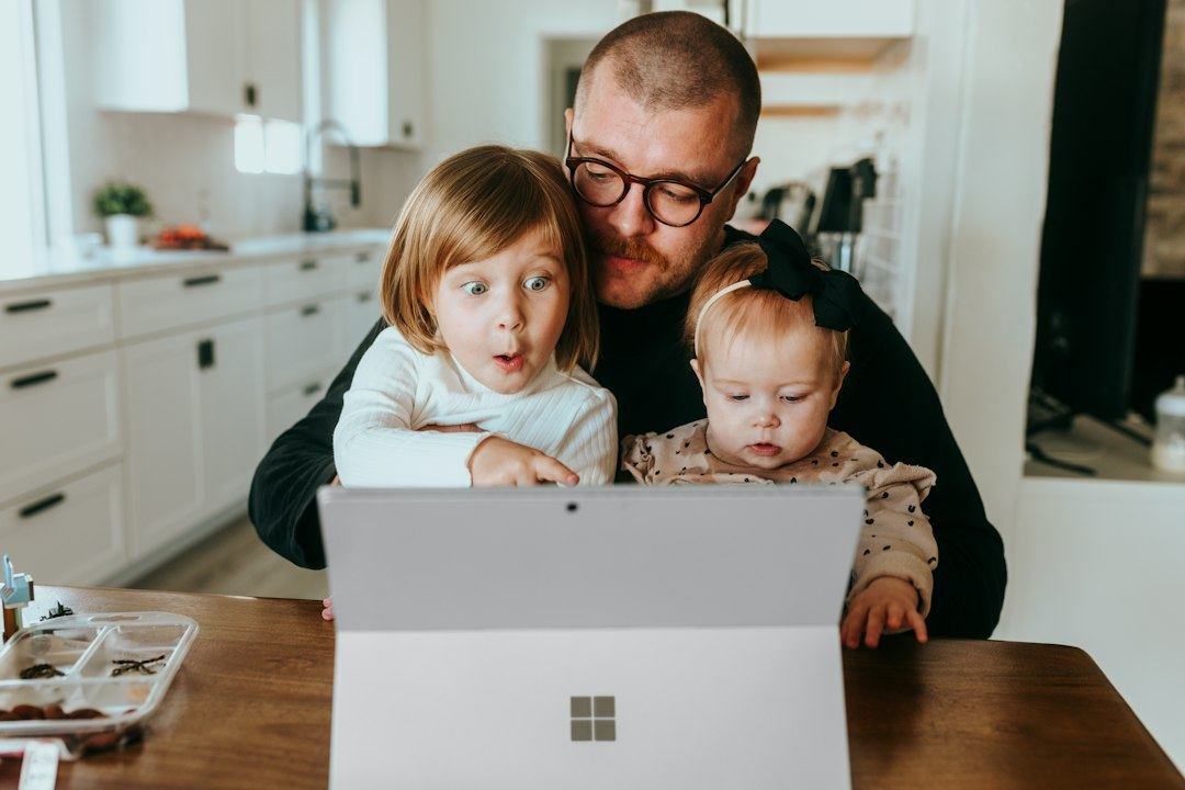 Parent and two children look at a laptop, symbolizing families applying for the Whatcom County childcare subsidy online