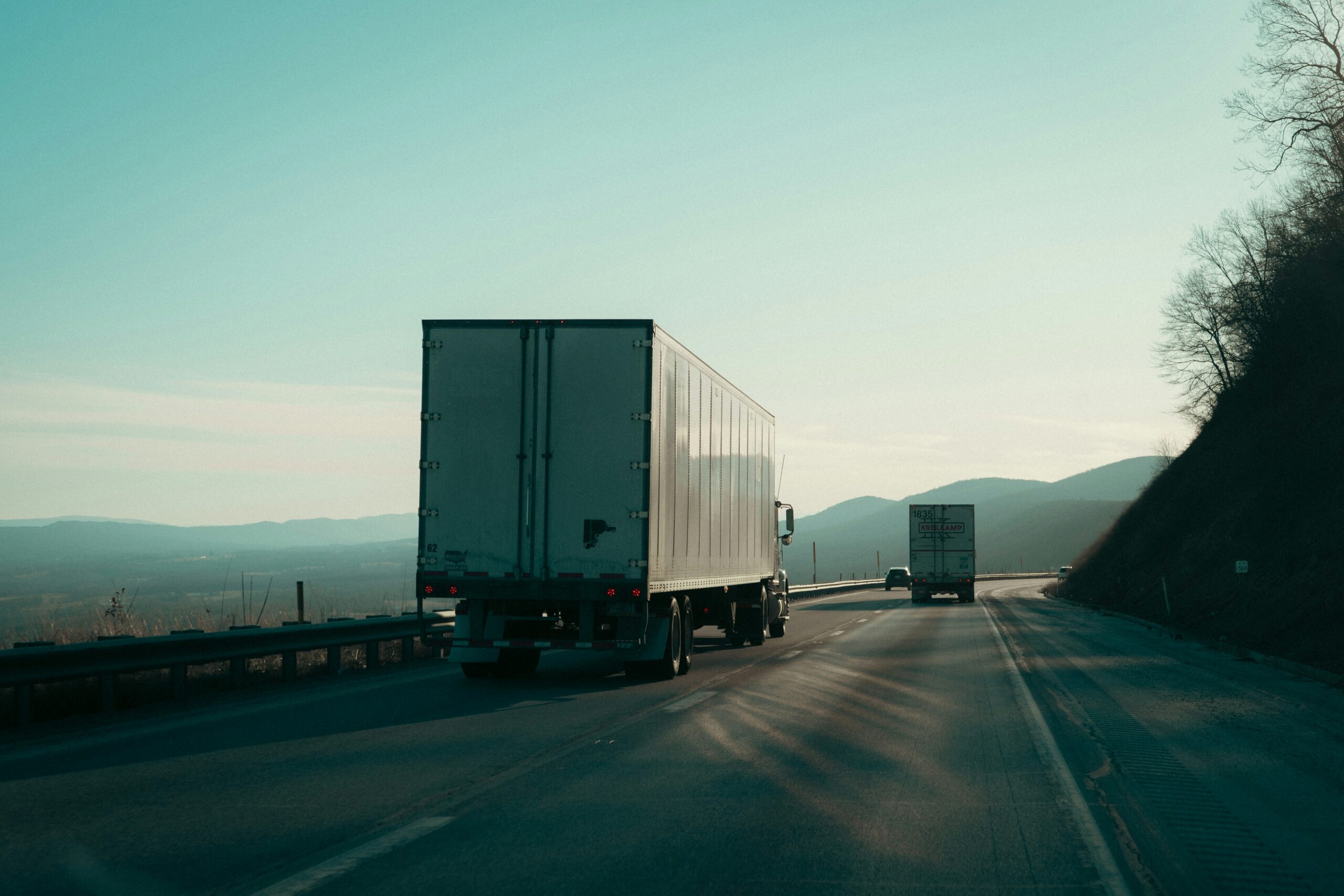 Semi trucks travel a highway, evoking Kodiak driverless trucking on the Dallas-Houston freight corridor