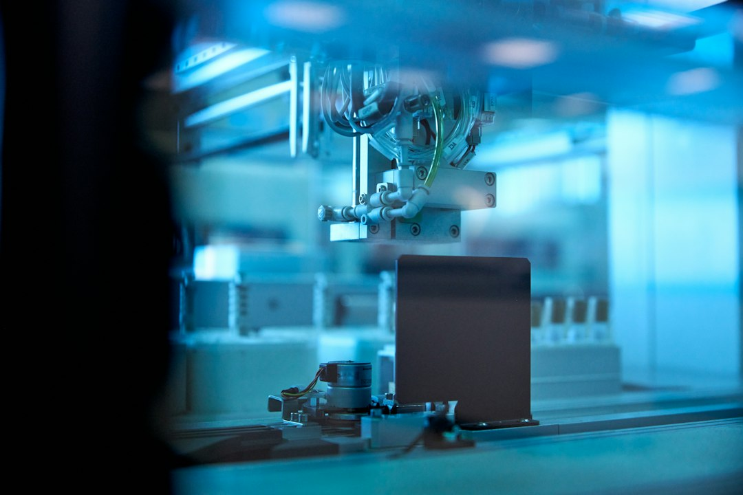 Industrial robotic arm in a blue-lit factory, symbolizing automated fuel pebble inspection