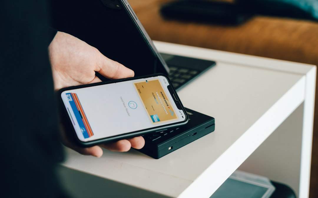 Hand holding a phone to pay, illustrating lower stablecoin remittance costs for everyday transfers